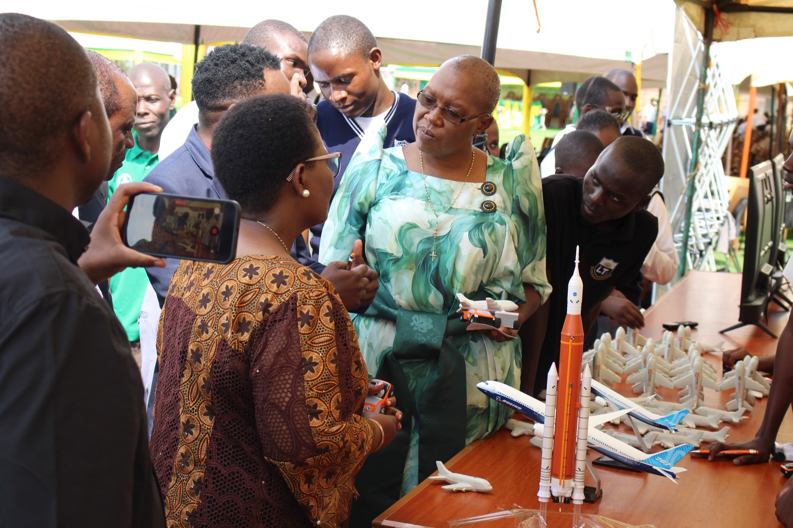Visitors and students gathered around the rocket and aircraft models on the exhibition table